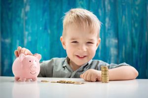 Bub mit Münzen und Sparschwein - OKIDS Kindergartenverwaltung